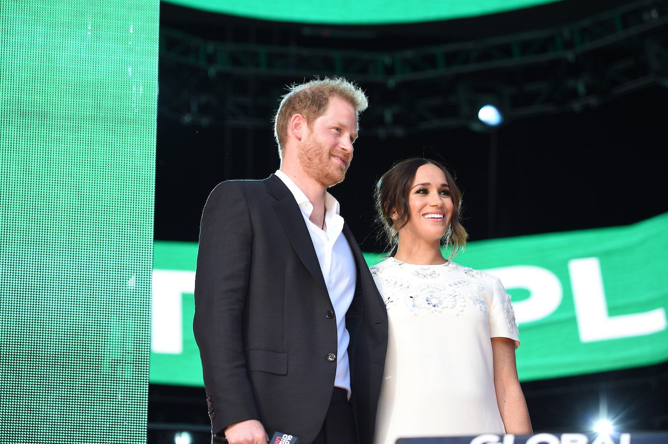 Prince Harry and Meghan Markle stand next to each other onstage