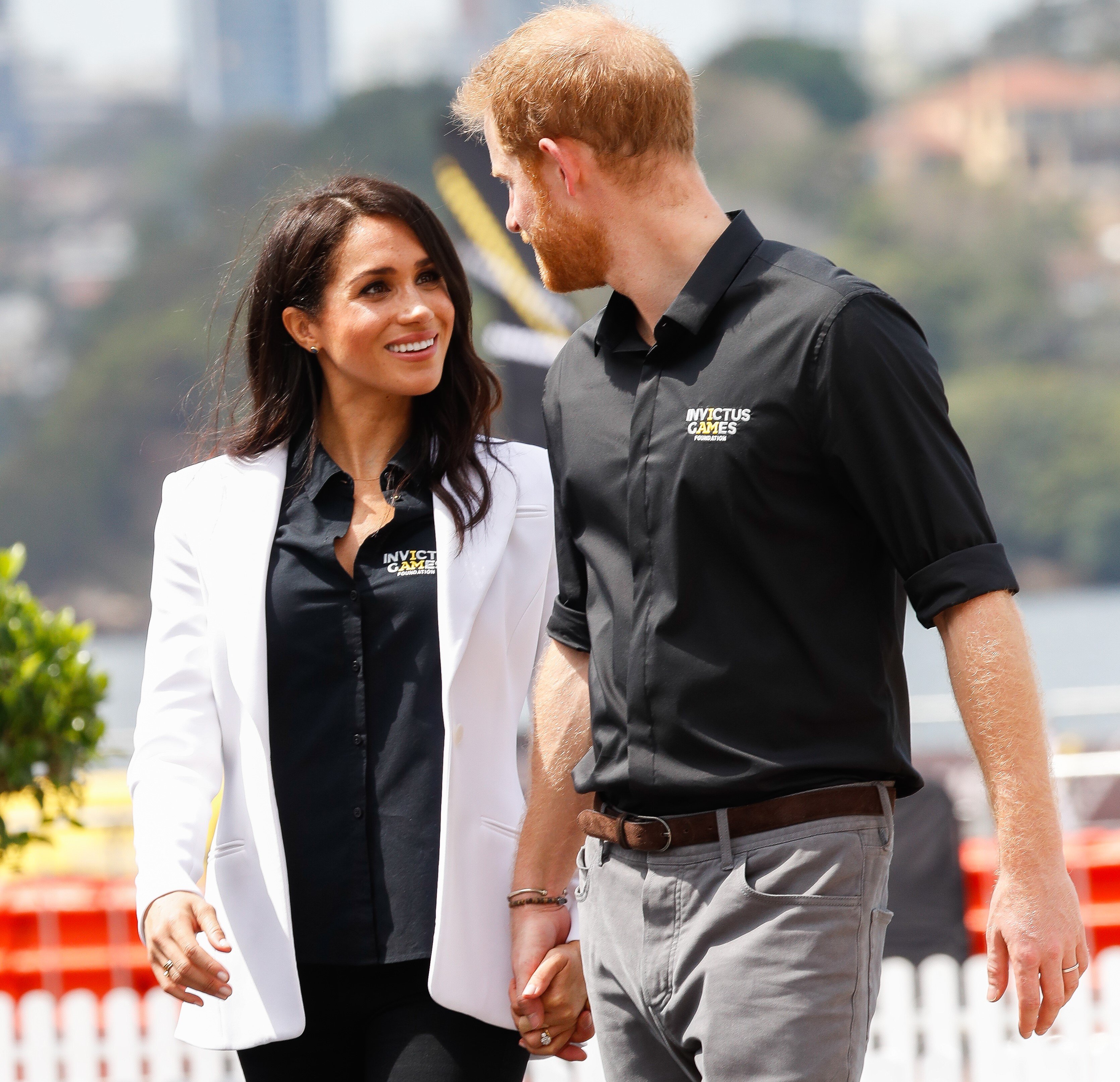 Prince Harry and Meghan holding hands during the JLR Drive Day at Cockatoo Island