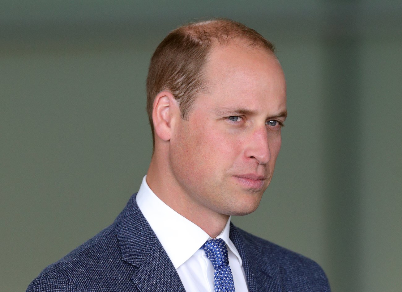 Prince William looking on, wearing a suit