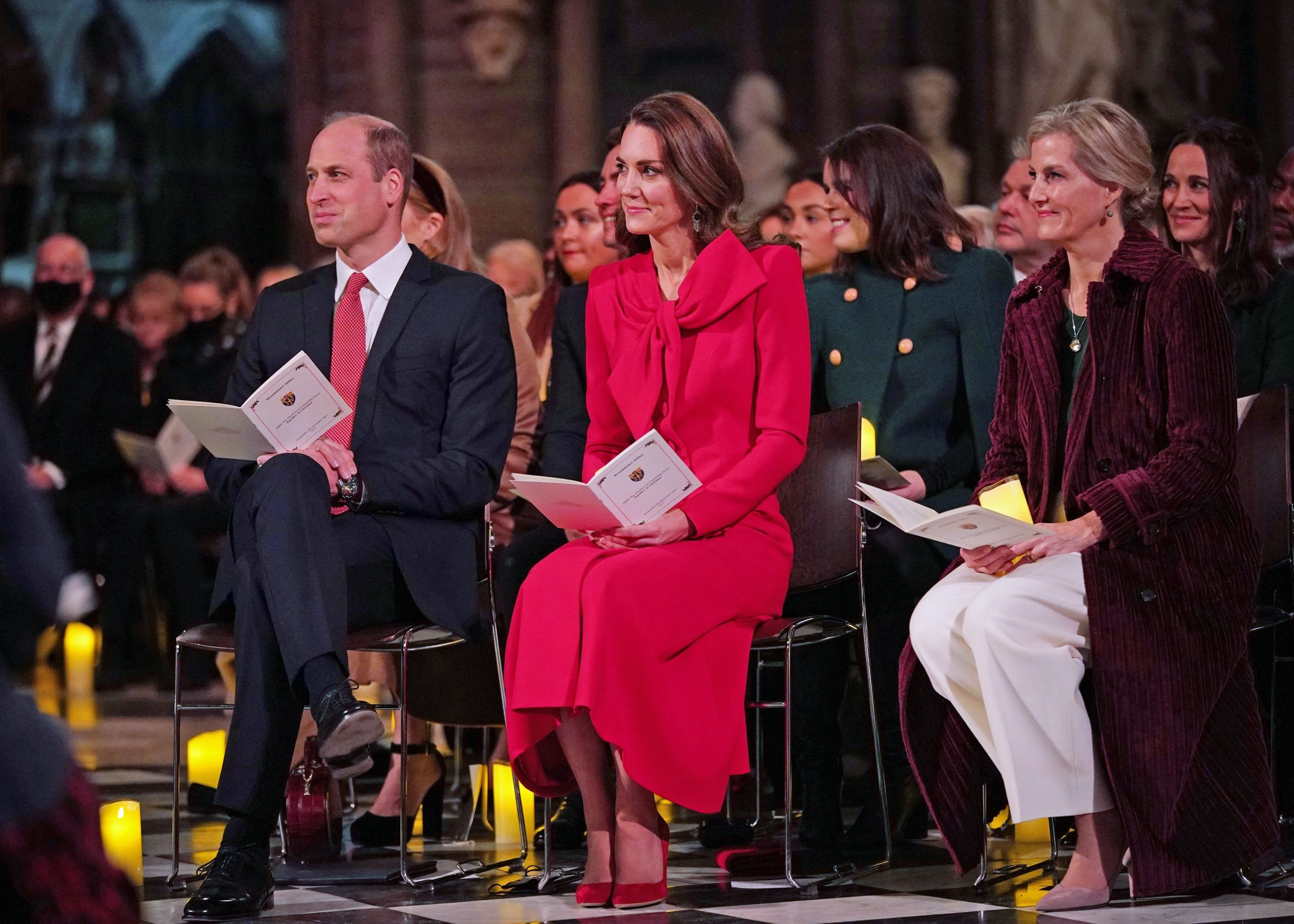 Prince William, Kate Middleton, and Sophie, Countess of Wessex sit next to each other as they hold programs