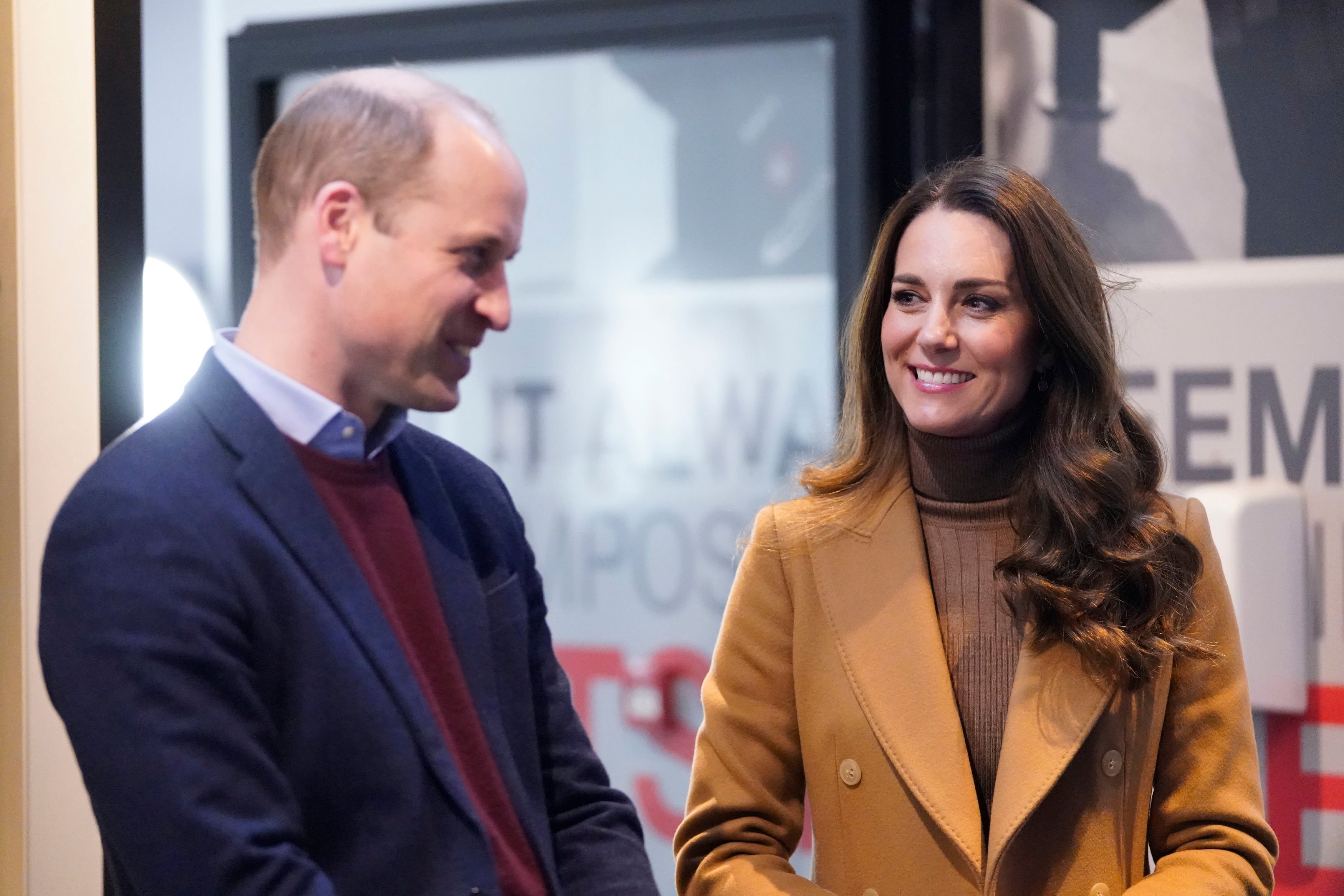 Prince William wearing a navy jacket and Kate Middleton in a beige coat during a visit to the Church on the Street in Burnley, England