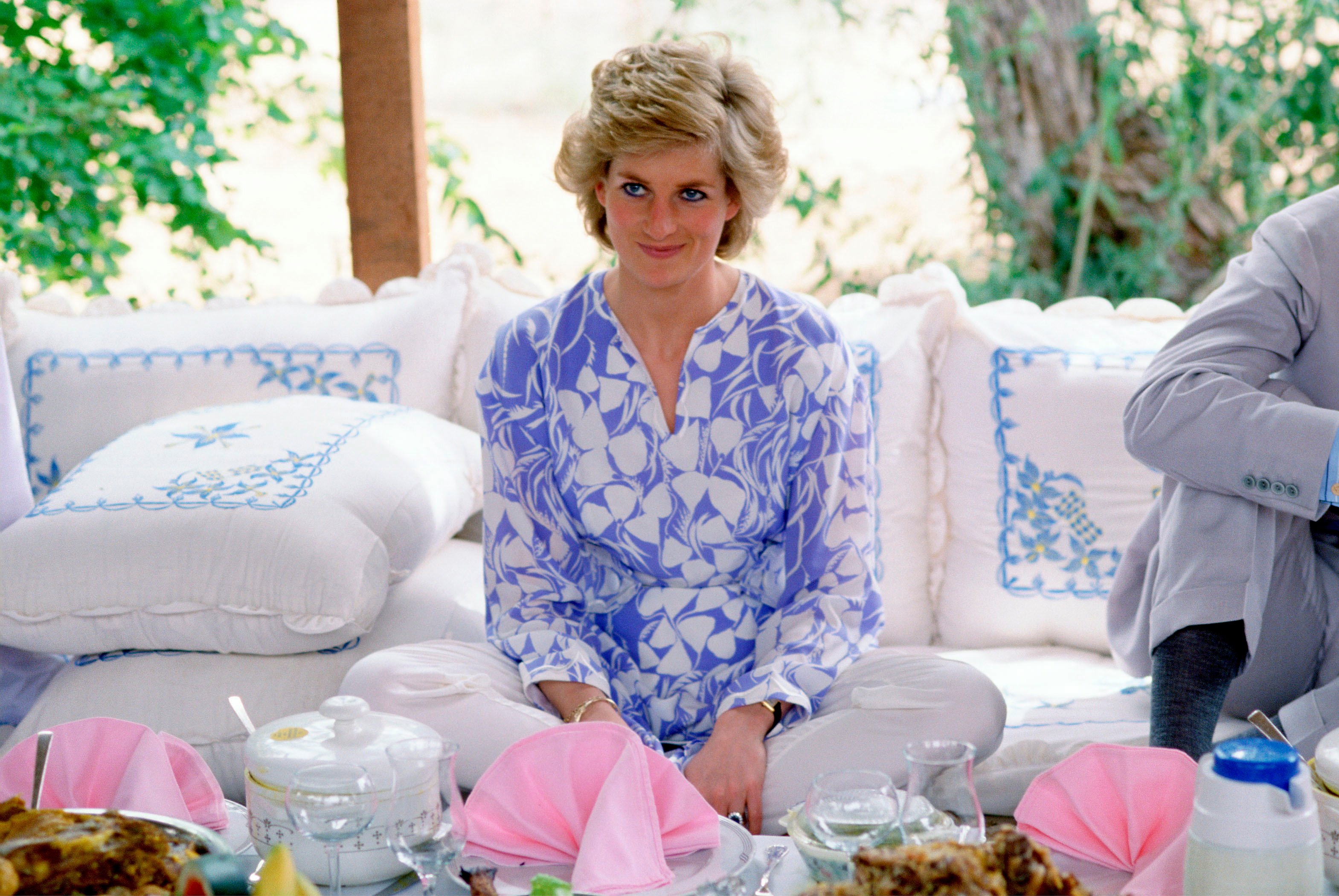 Princess Diana sitting cross-legged on cushions at a Bedouin-style picnic lunch