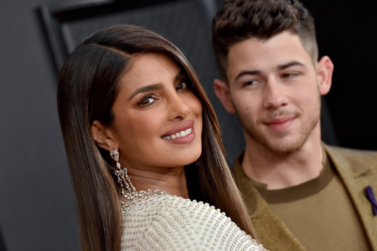 Priyanka Chopra smiling with Nick Jonas in the background