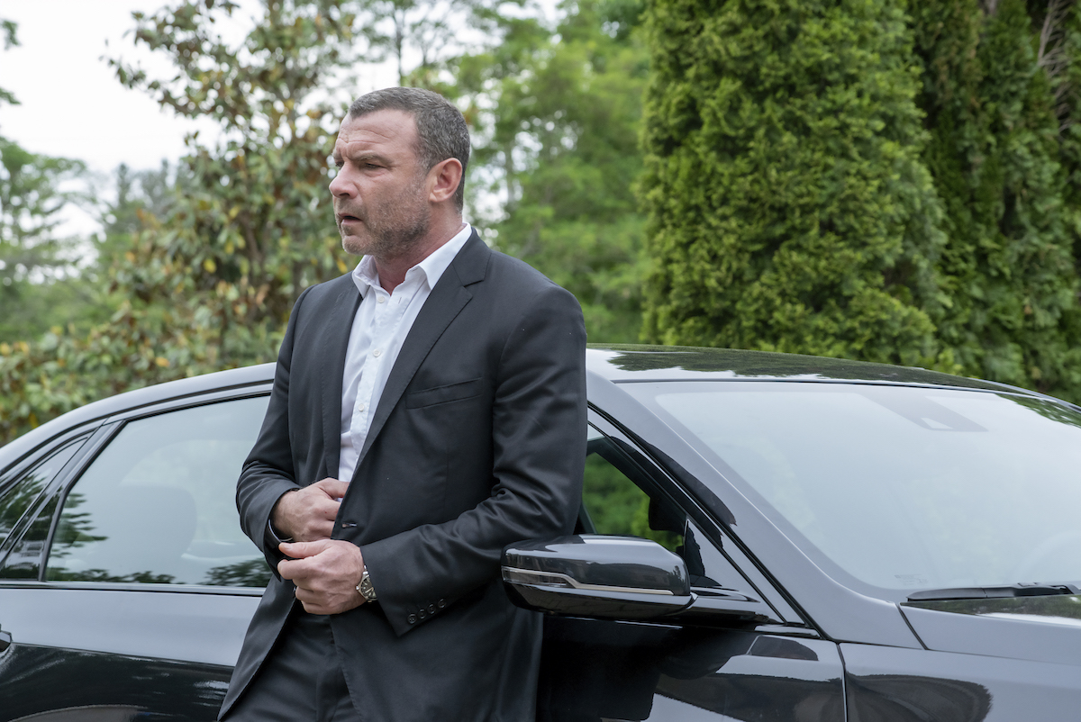 Liev Schreiber as Ray Donovan leaning against a car in 'Ray Donovan: The Movie'