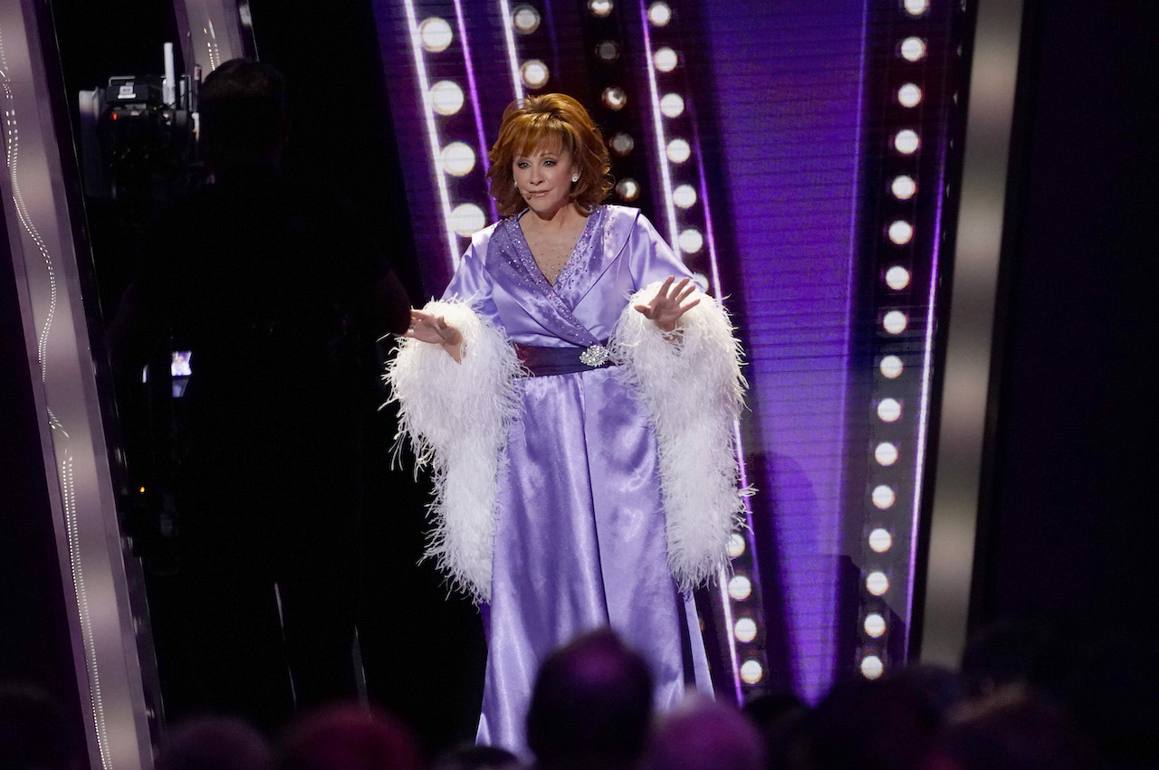 Reba McEntire in a light purple, silky robe with feather trim