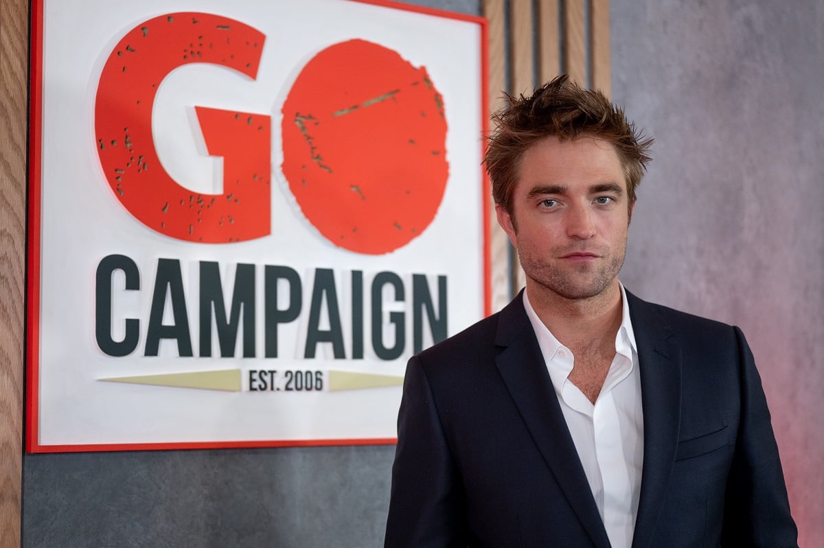 Robert Pattinson posing in a suit.