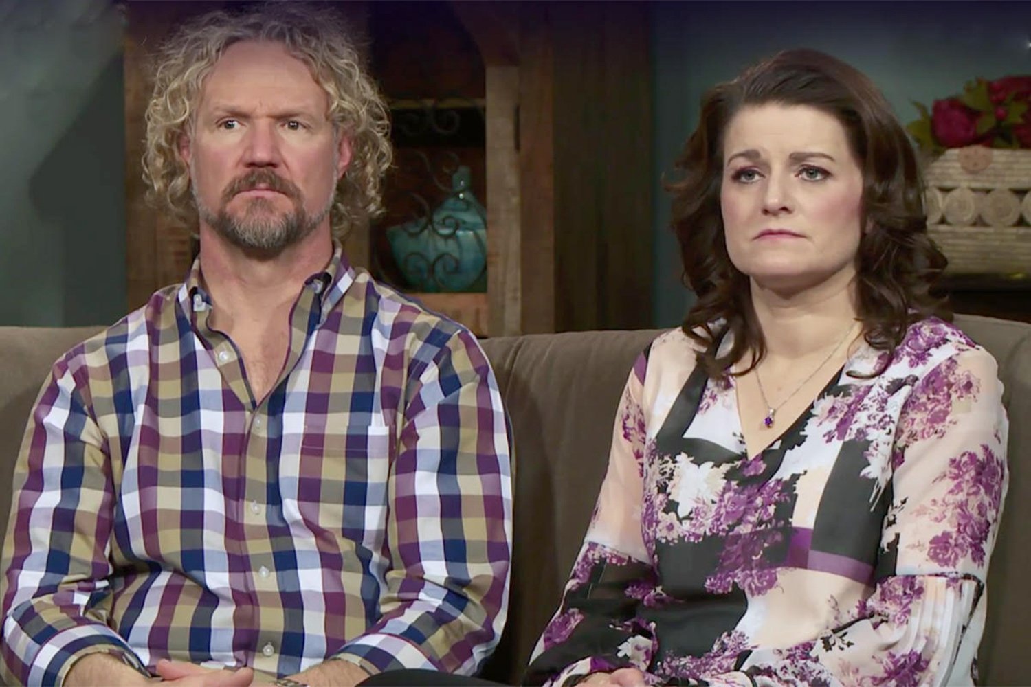 Kody Brown wearing a flannel shirt sitting next to Robyn Brown, who is wearing a floral shirt on,'Sister Wives' | TLC