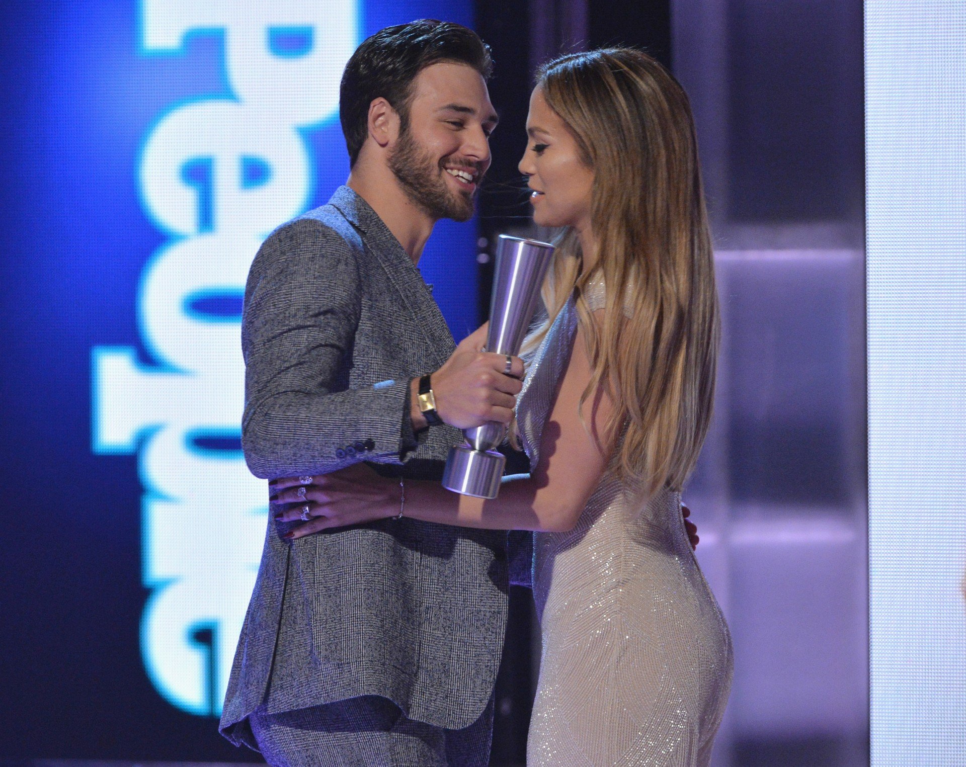 Ryan Guzman and Jennifer Lopez embrace during an awards show