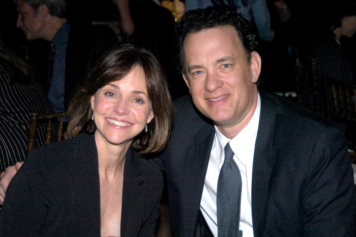 Sally Field and Tom Hanks wear dark clothes as they pose at an event