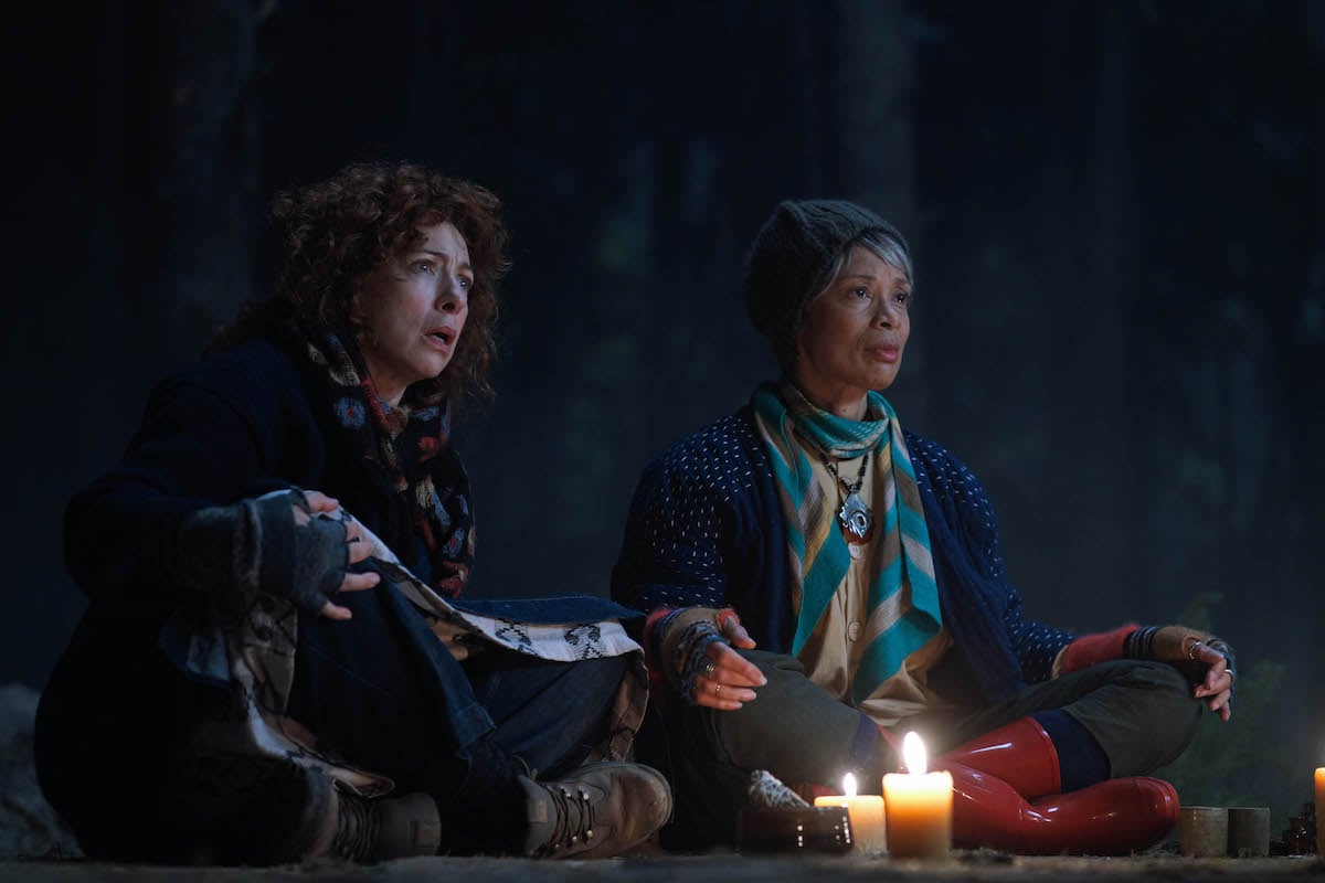 Aunt Sarah and Aunt Emily sitting by a fire in 'A Discovery of Witches' Season 2