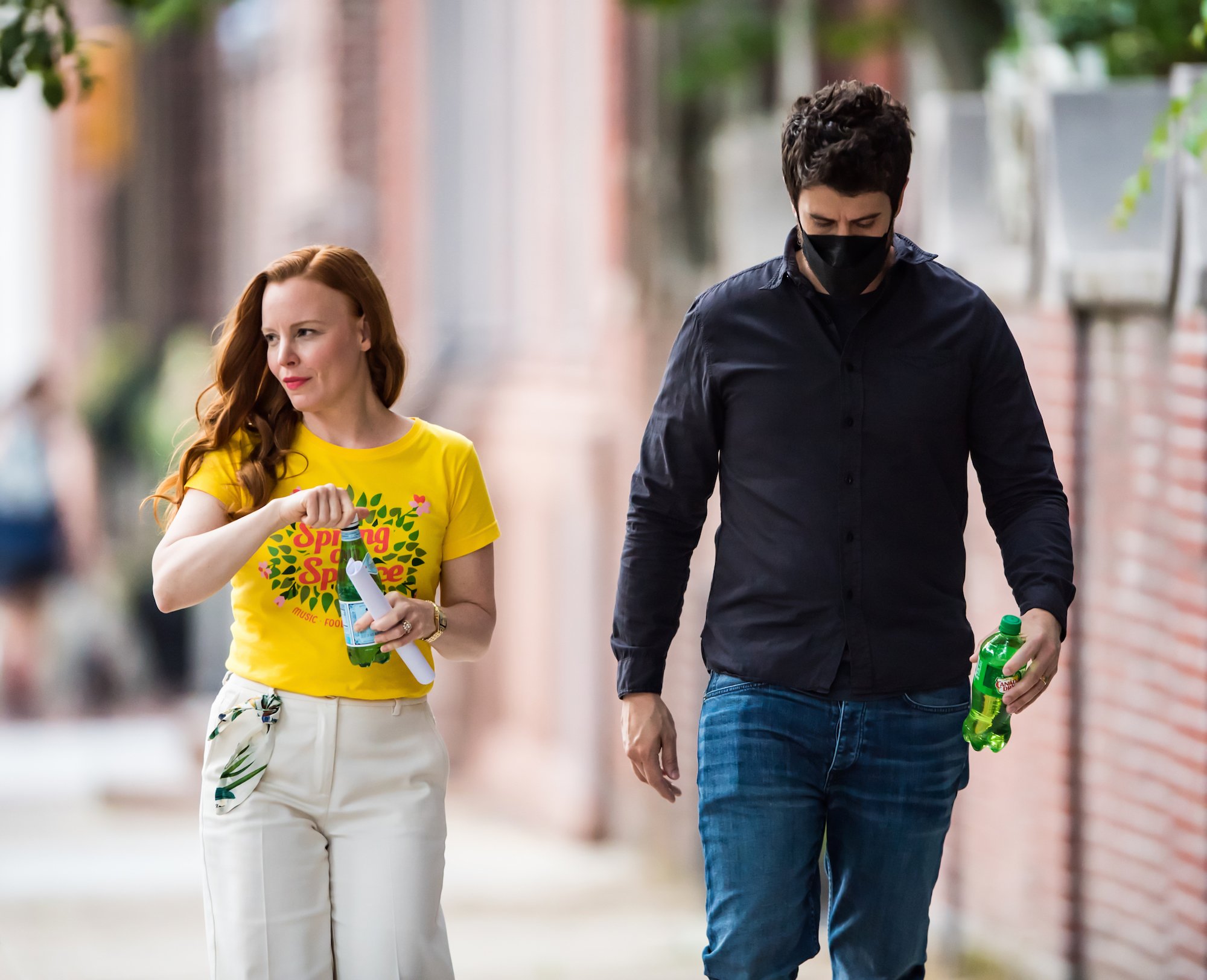 'Servant' Season 3 stars Lauren Ambrose in a yellow tshirt and white pants walking with Toby Kebbell in a dark shirt in jeans, on a street in Philadelphia
