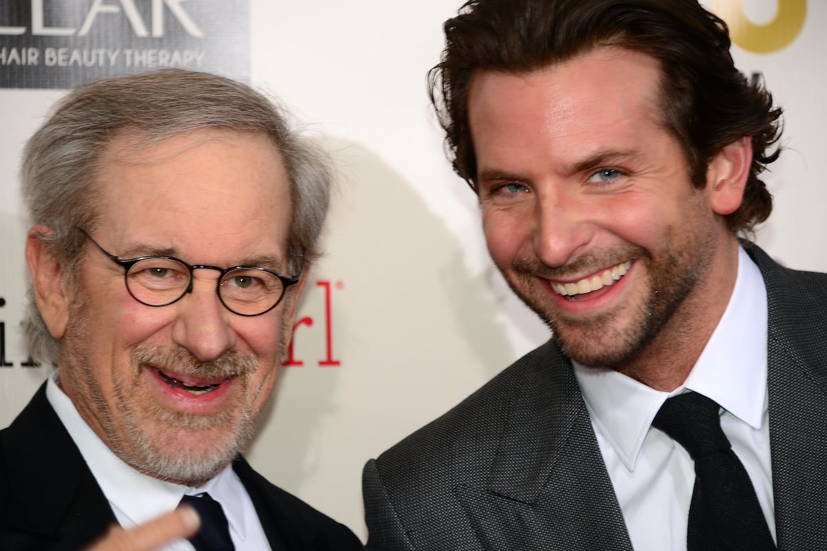 Steven Spielberg and Bradley Cooper smile in suits as they pose on the red carpet