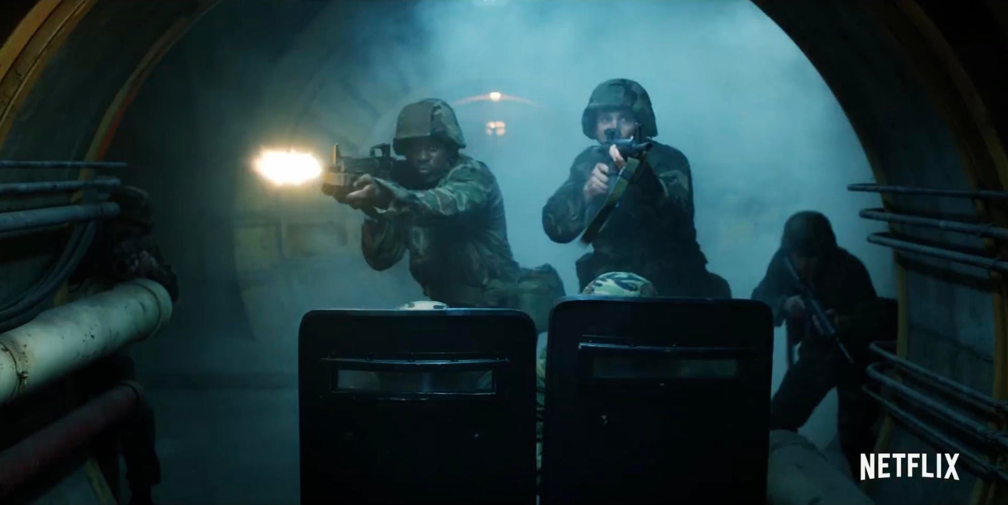 Members of a military group hold up guns in what appears to be an underground bunker in 'Stranger Things 4'