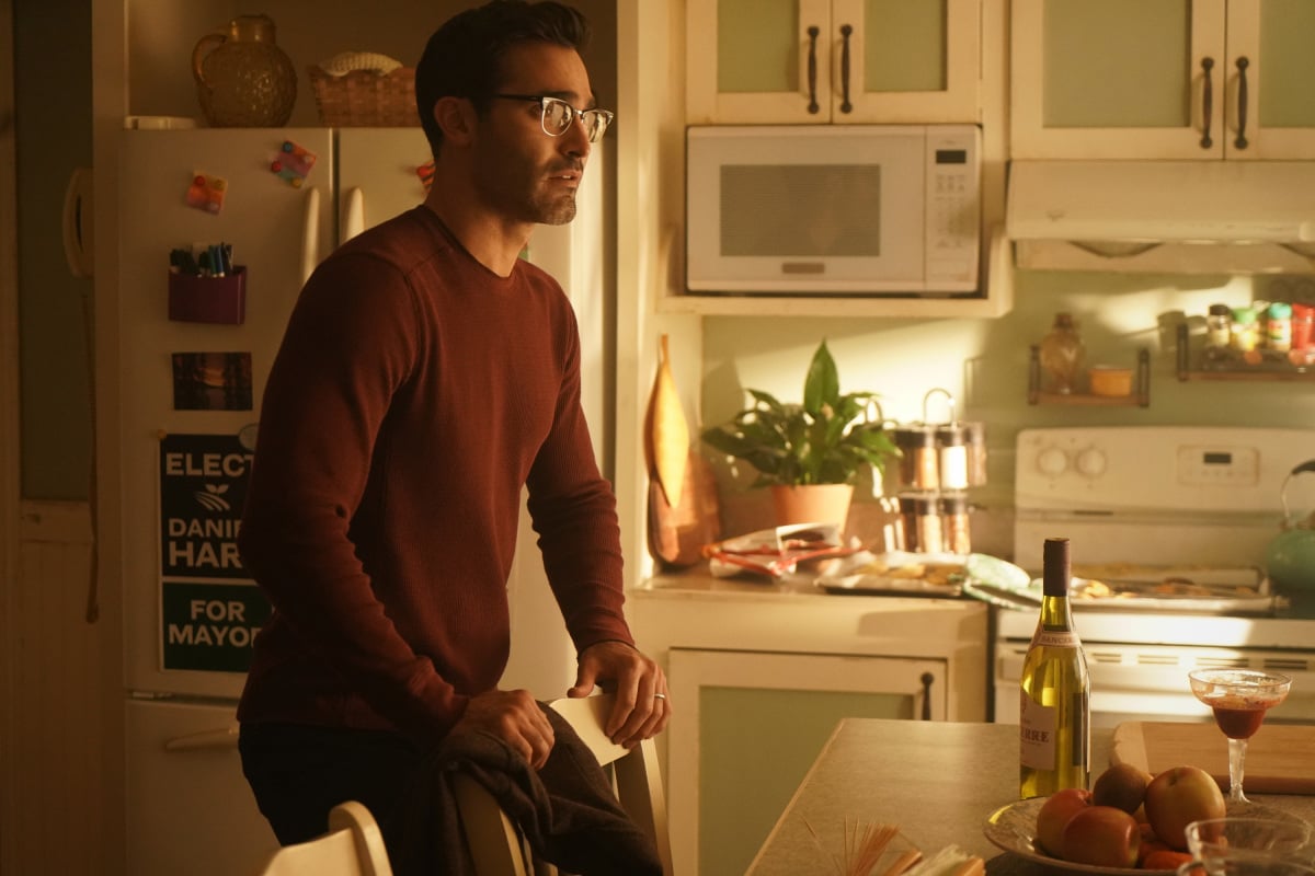 'Superman & Lois' Season 2 star Tyler Hoechlin, in character as Clark Kent, wears a red sweater and glasses. A recap of 'Superman & Lois' Season 2 Episode 1 teases the villain of the season.