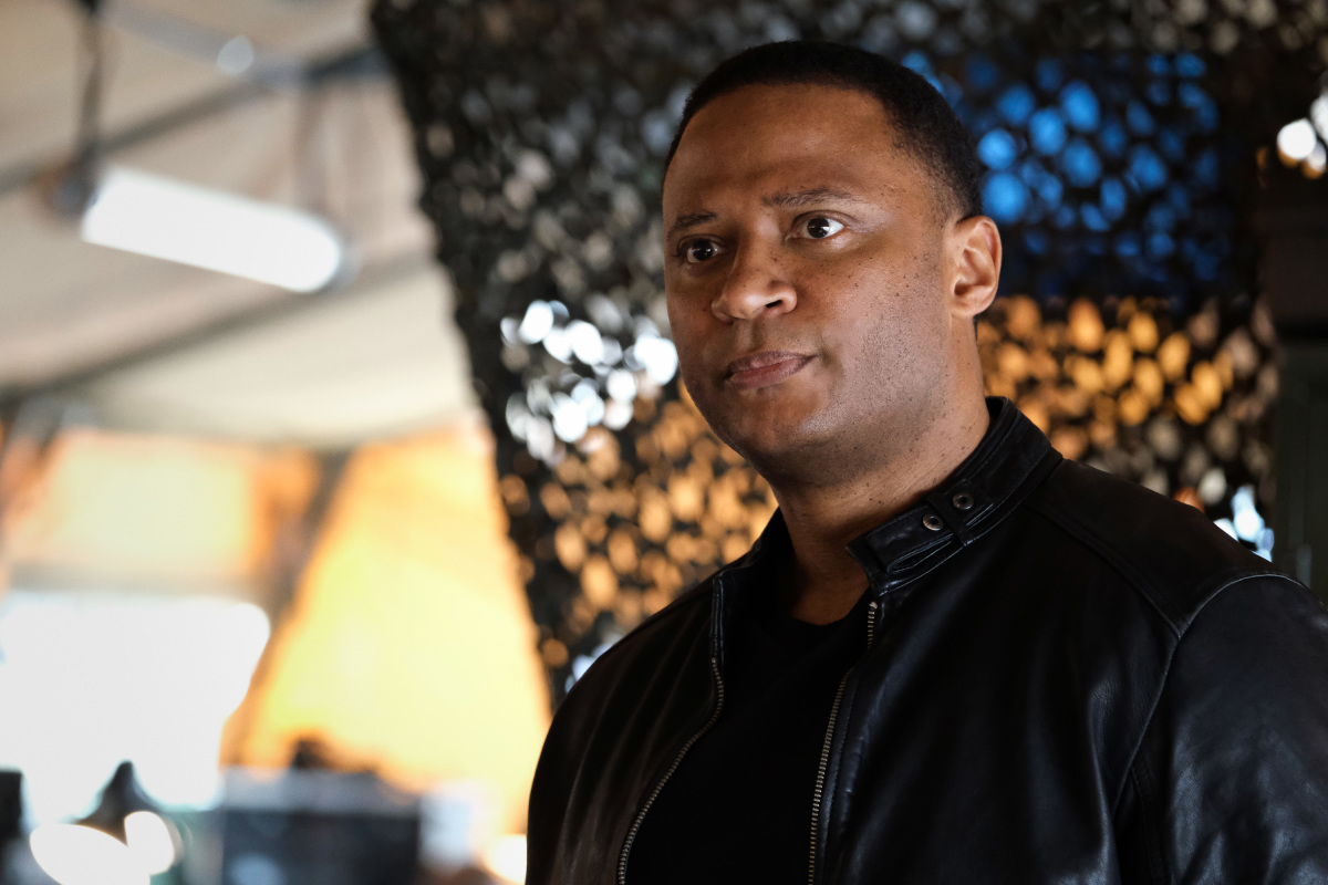 'Superman & Lois' Season 2 guest star David Ramsey, in character as John Diggle, wears a black leather jacket over a black shirt.