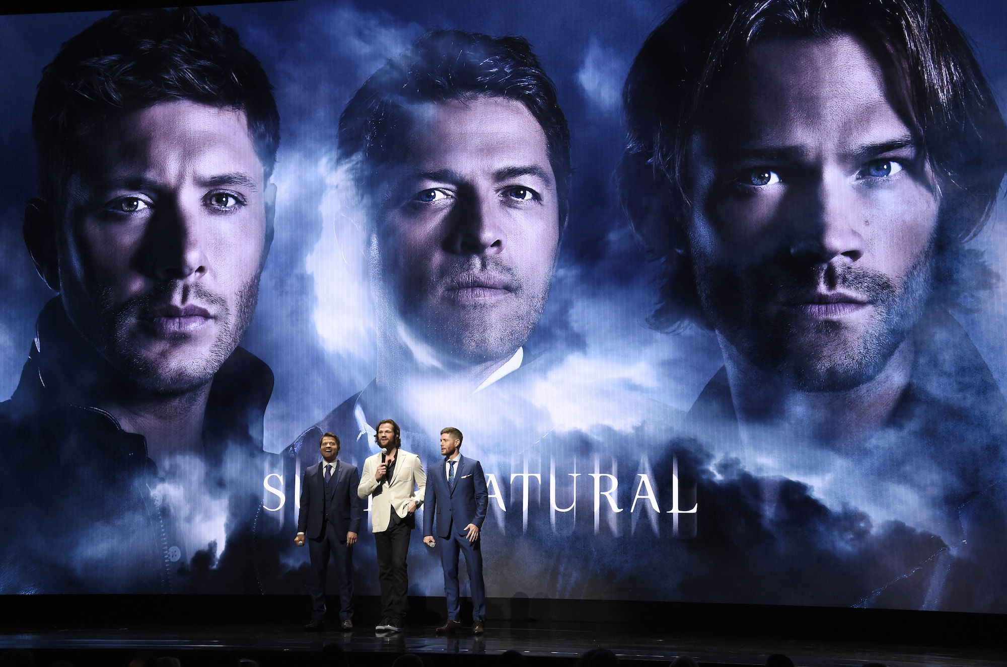 'Supernatural' stars Misha Collins, Jared Padalecki and Jensen Ackles stand in front of their poster