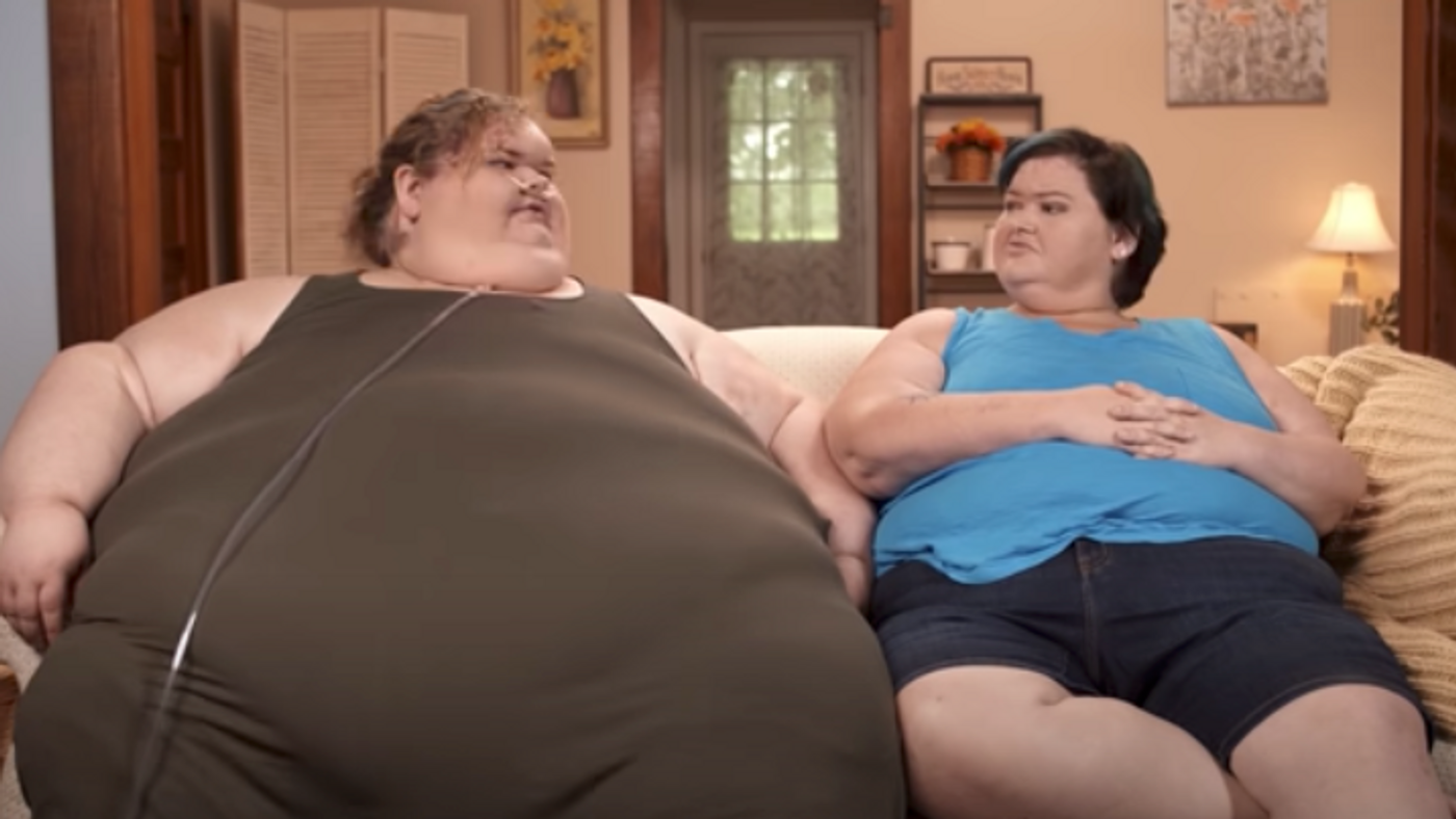 Tammy and Amy Slaton sitting on a couch together in an episode of '1000-lb Sisters'