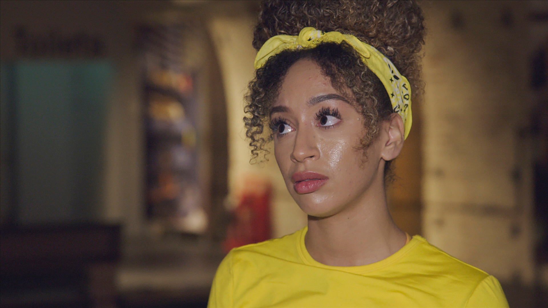 'The Amazing Race' Season 33 contestant Caro Viehweg wears a yellow shirt and a yellow bandana around her head.