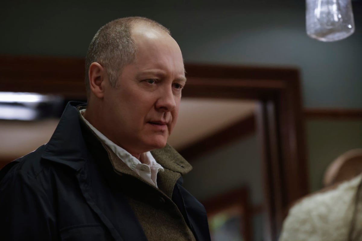 James Spader as Raymond Reddington in The Blacklist Season 9. Red wears a jacket with a white-collared shirt underneath and looks serious.