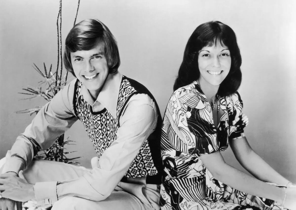 The Carpenters' Richard and Karen Carpenter near a plant