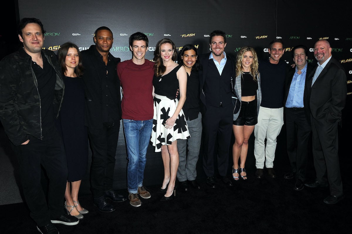 'The Flash' cast and crew members smiling in front of a black background