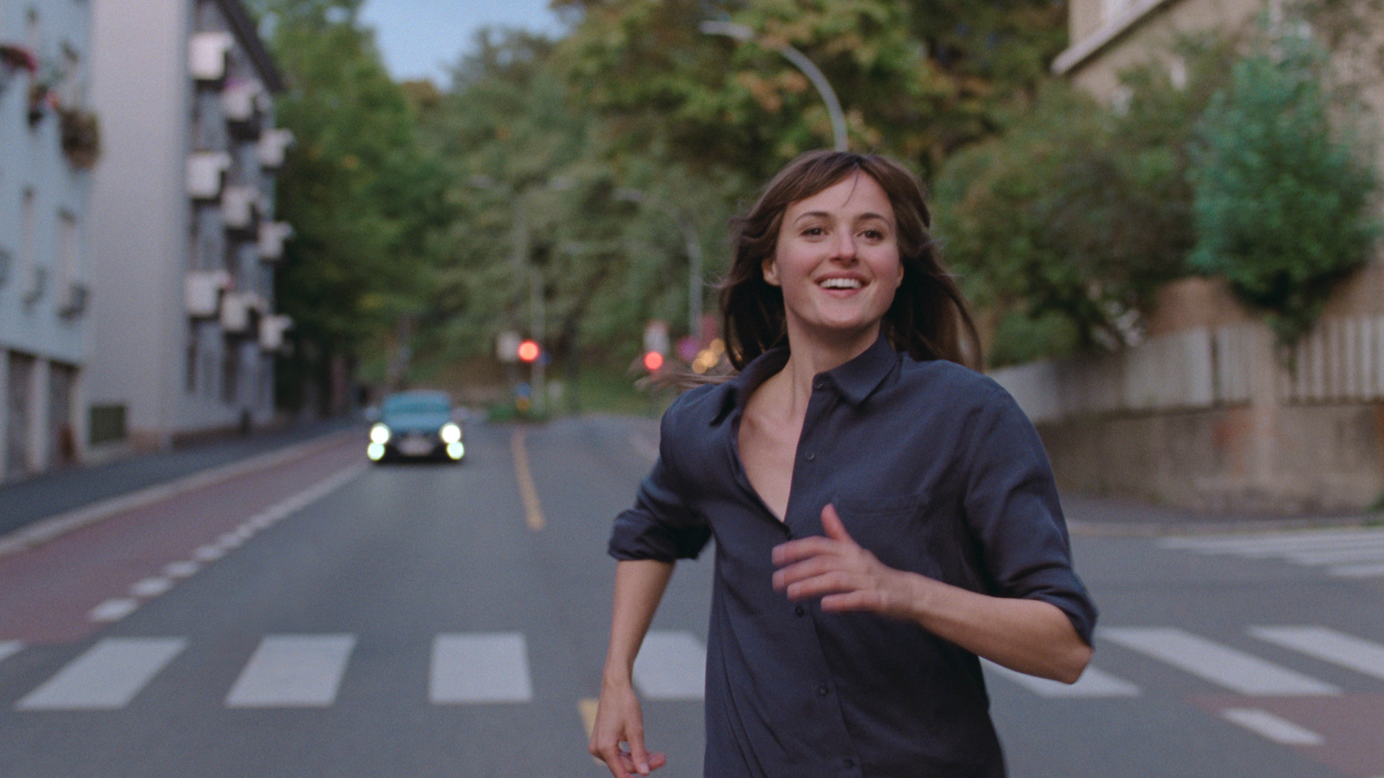 'The Worst Person in the World' Renate Reinsve as Julie running down the street in a navy blue shirt