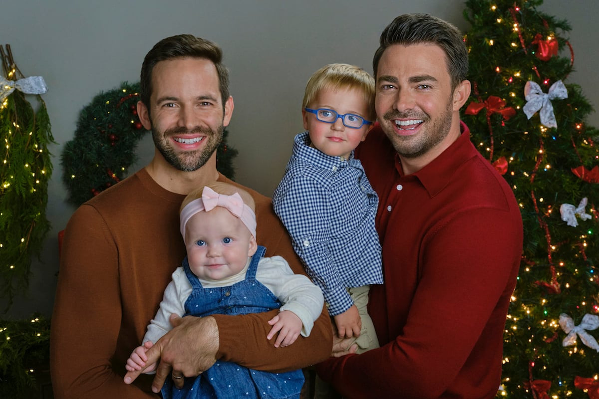 Brad Harder as Jack and Jonathan Bennett at Brandon pose with their two young children in a scene from 'The Christmas House 2: Deck Those Halls' 