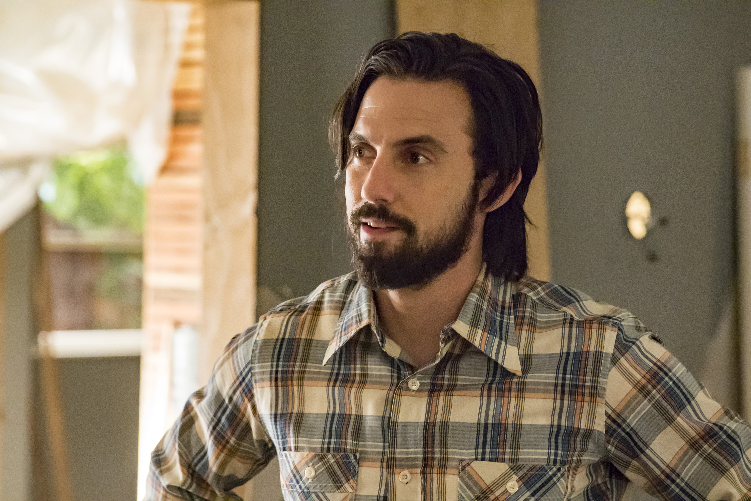 'This Is Us' Season 6 star Milo Ventimiglia, in character as Jack Pearson, wears a blue and white long-sleeved button-up plaid shirt.