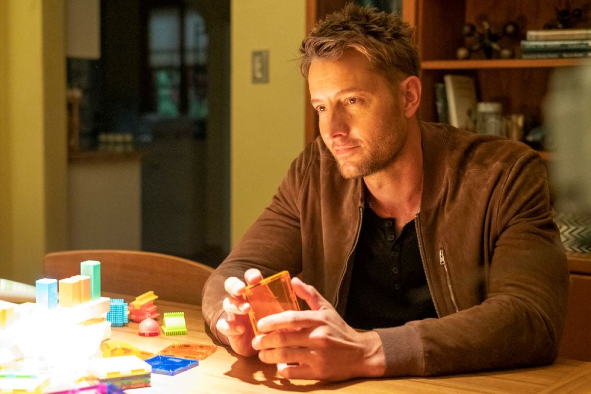'This Is Us' Season 6 star Justin Hartley, in character as Kevin Pearson, wears a brown jacket over a black shirt.