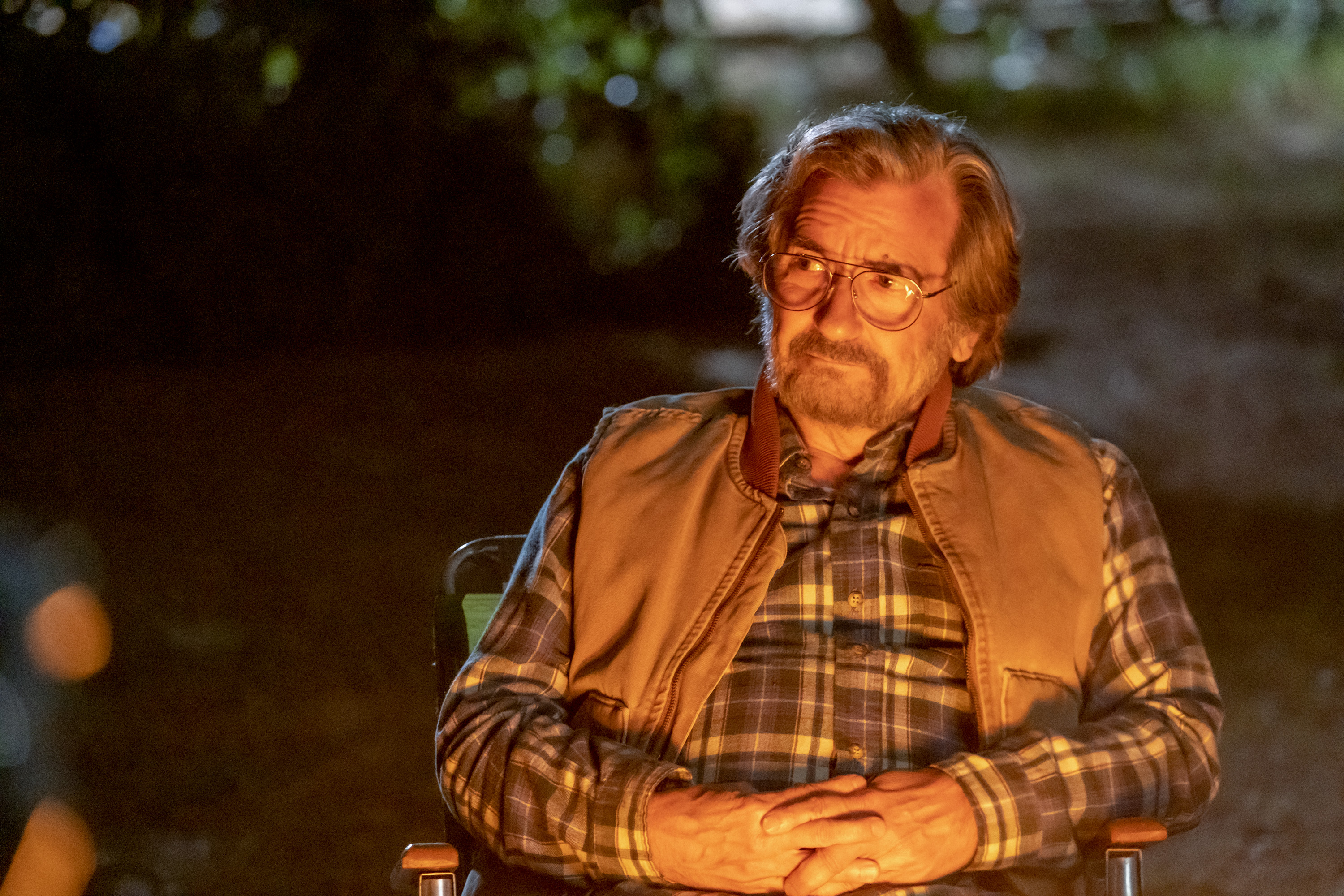 'This Is Us' Season 6 star Griffin Dunne, in character as Nicky who is married to Edie in the future, wears a blue plaid shirt and a brown vest.