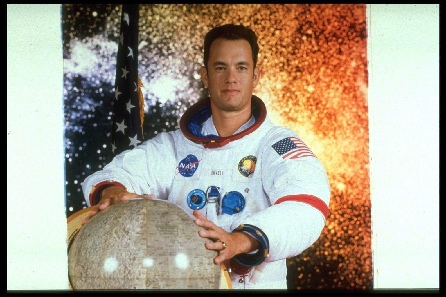 Tom Hanks wears a spacesuit and holds a globe in 'Apollo 13'