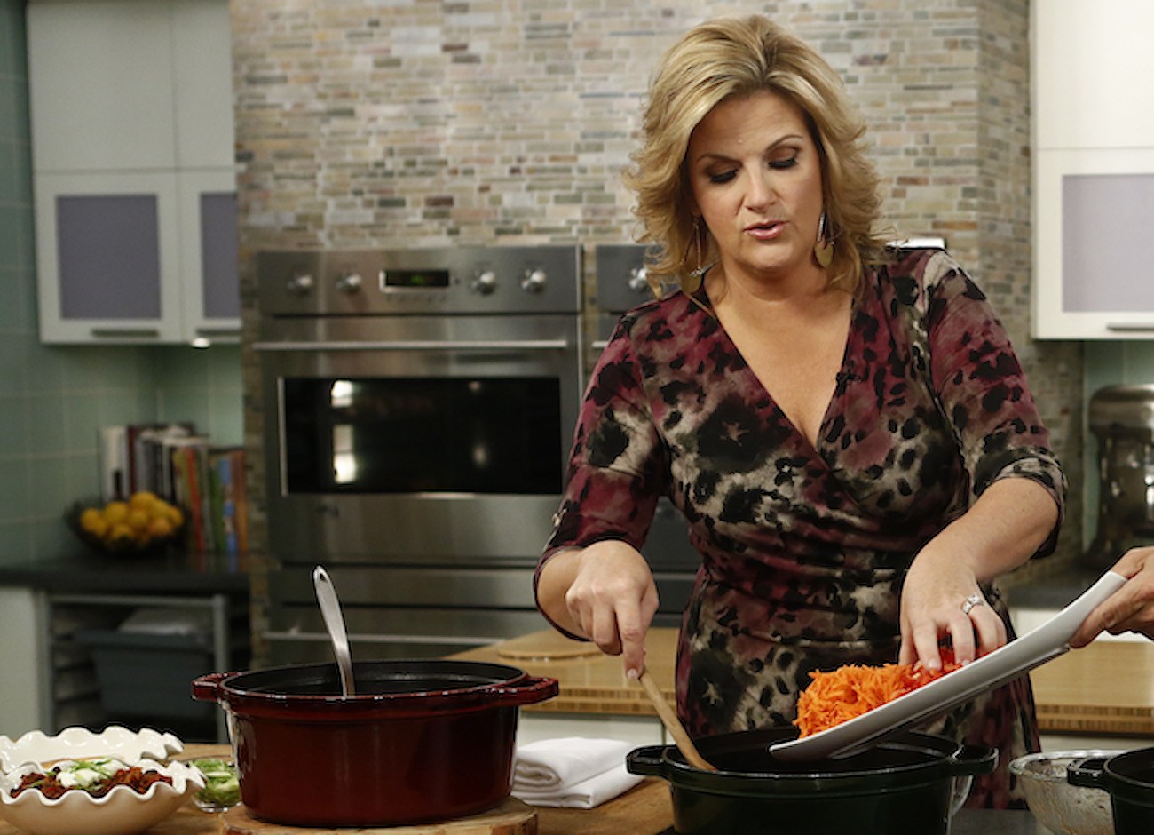 Trisha Yearwood puts an ingredient into a pot during a cooking demo on 'Today'