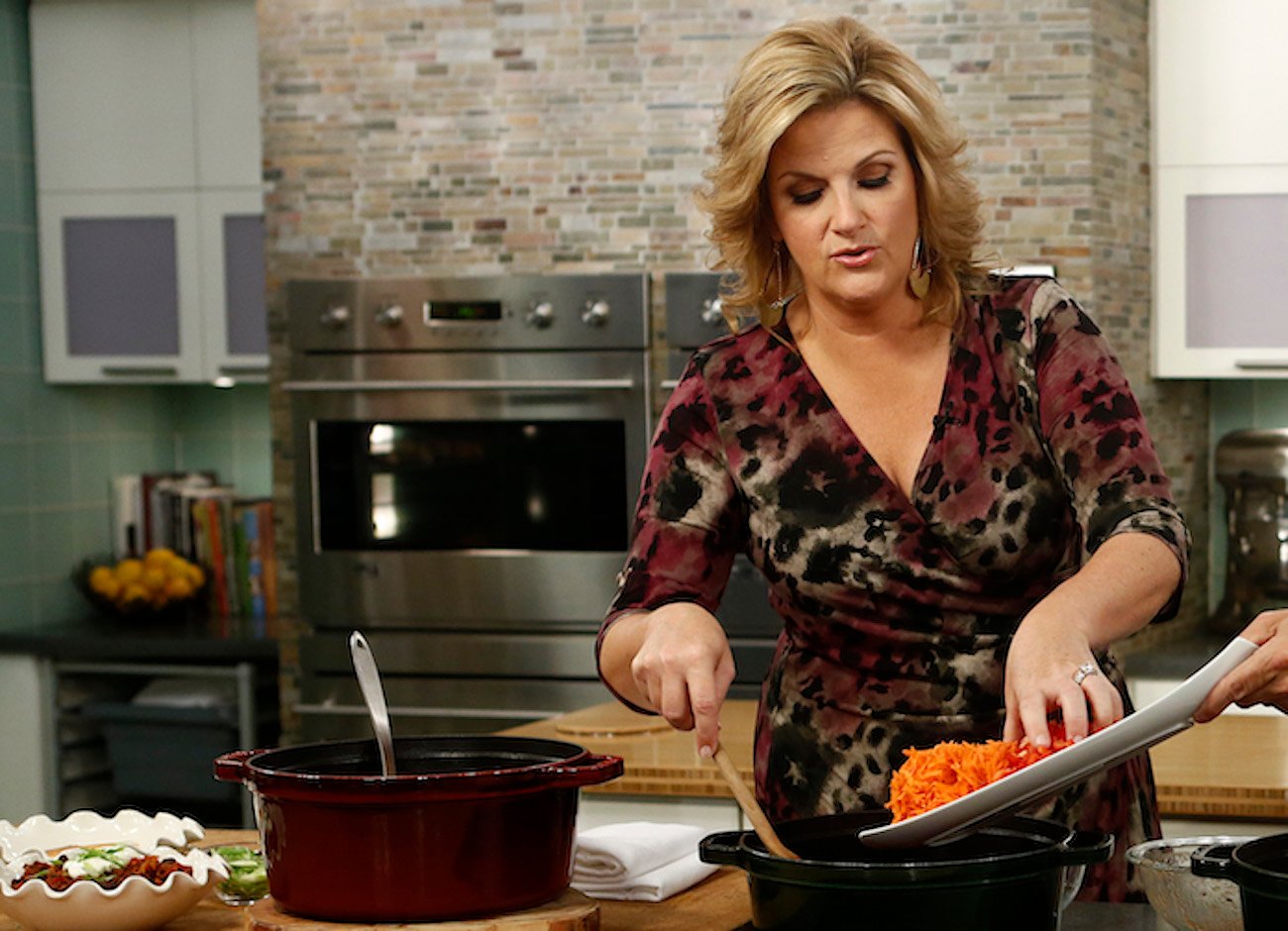 Trisha Yearwood puts an ingredient into a pot during a cooking demo on 'Today'