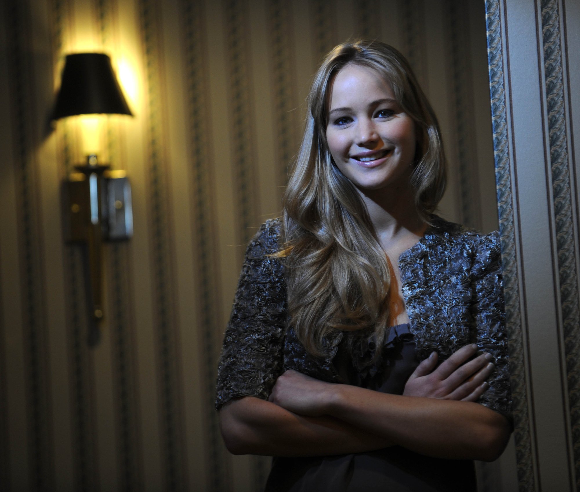 'Winter's Bone' star Jennifer Lawrence leaning against a wall with a lamp behind her