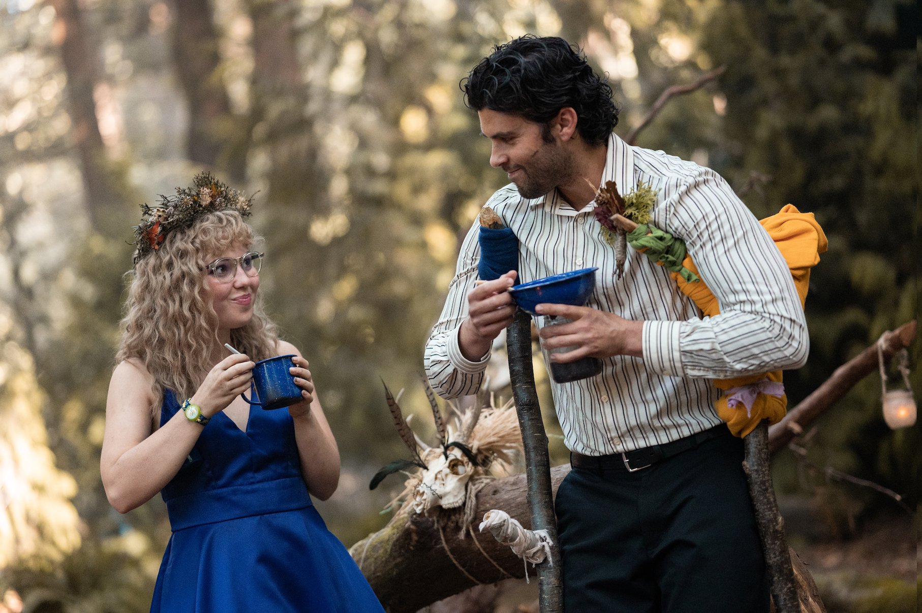 Misty and Coach Ben standing together and smiling at each other in the woods in 'Yellowjackets'