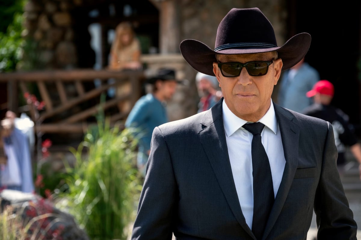 Yellowstone season 5 star Kevin Costner as John Dutton in a suit, cowboy, hat, and sunglasses