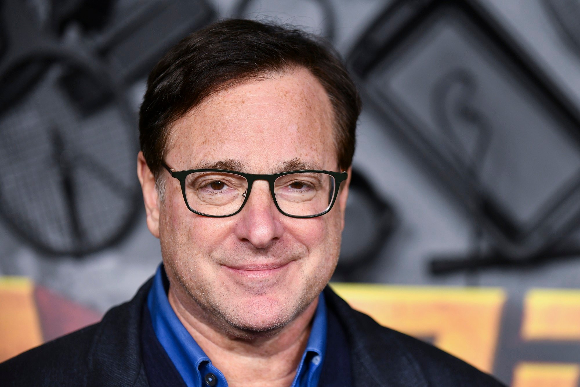 Bob Saget smiling on a red carpet