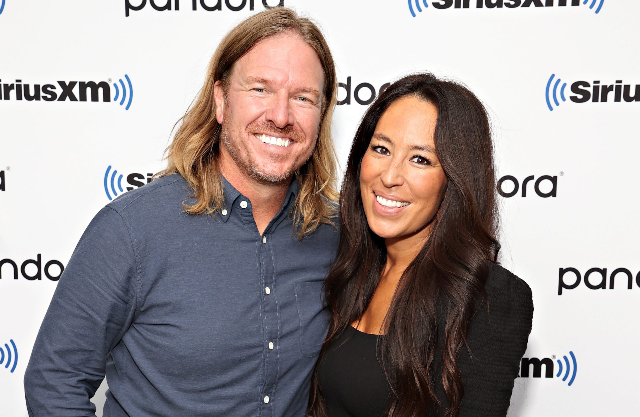 Chip and Joanna Gaines posing together and smiling for the camera against a SiriusXM backdrop