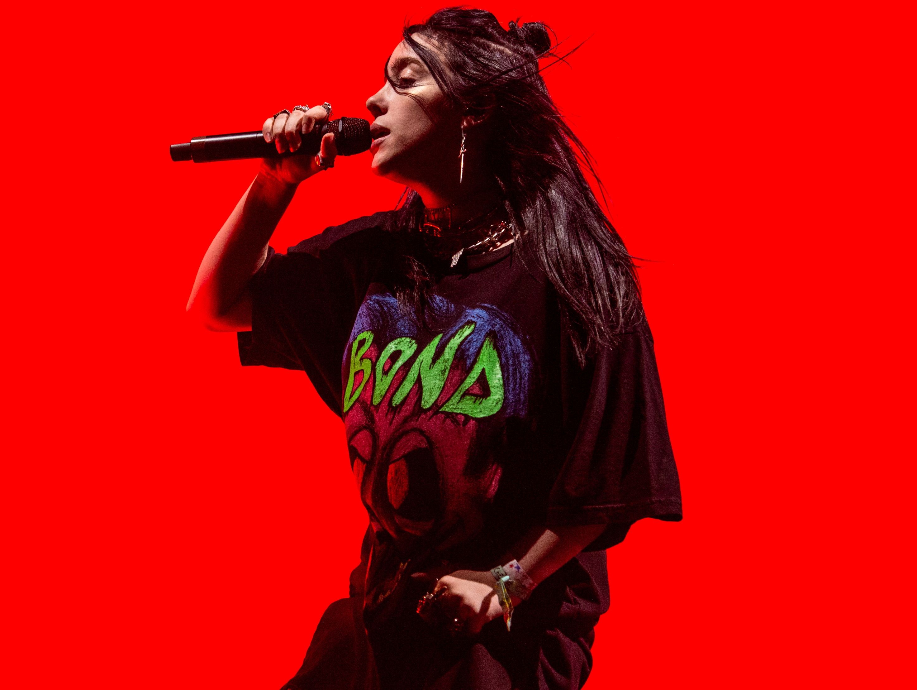 Billie Eilish performing with a red background at Coachella 2019