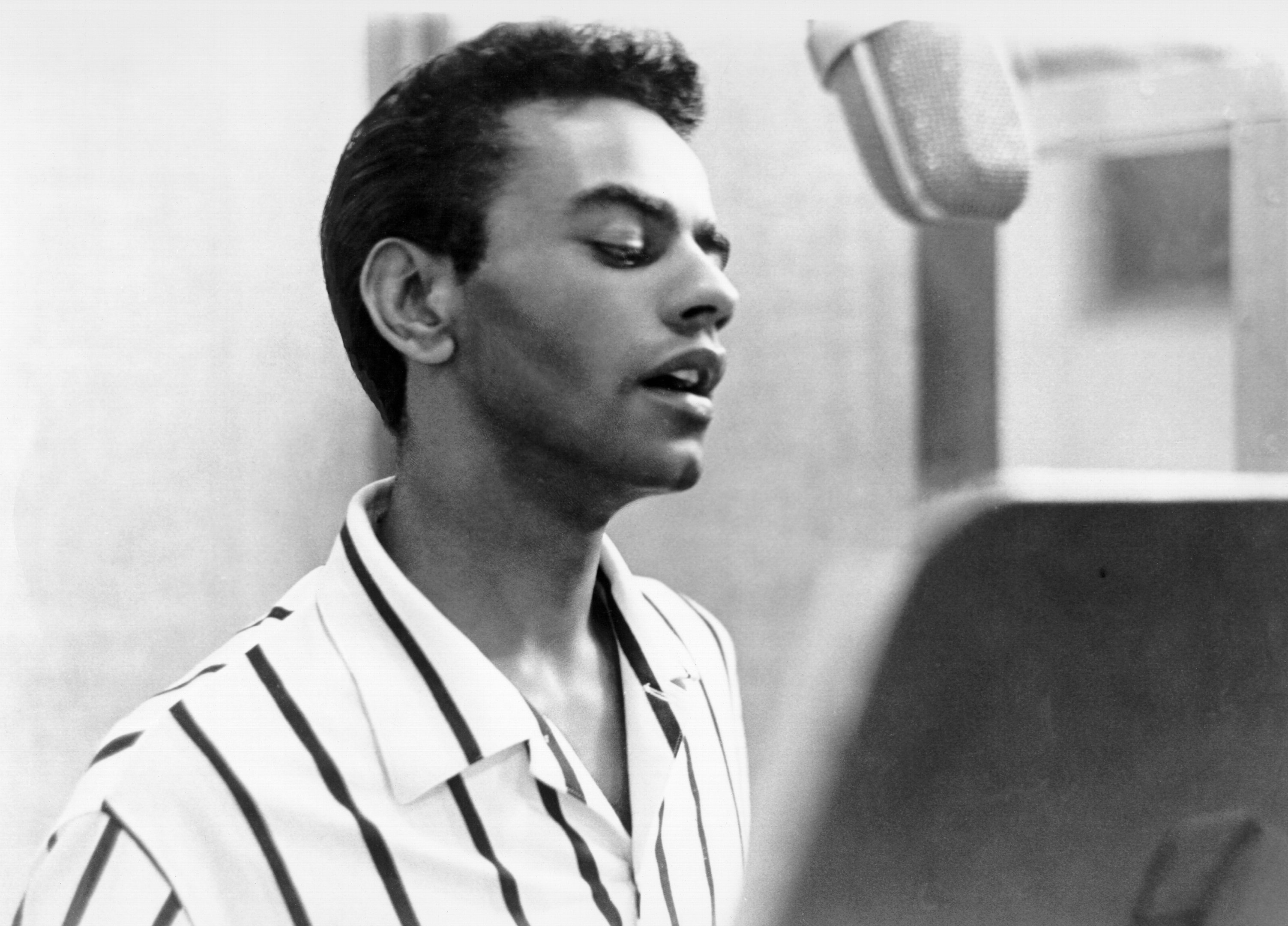 Johnny Mathis leaning against a wall