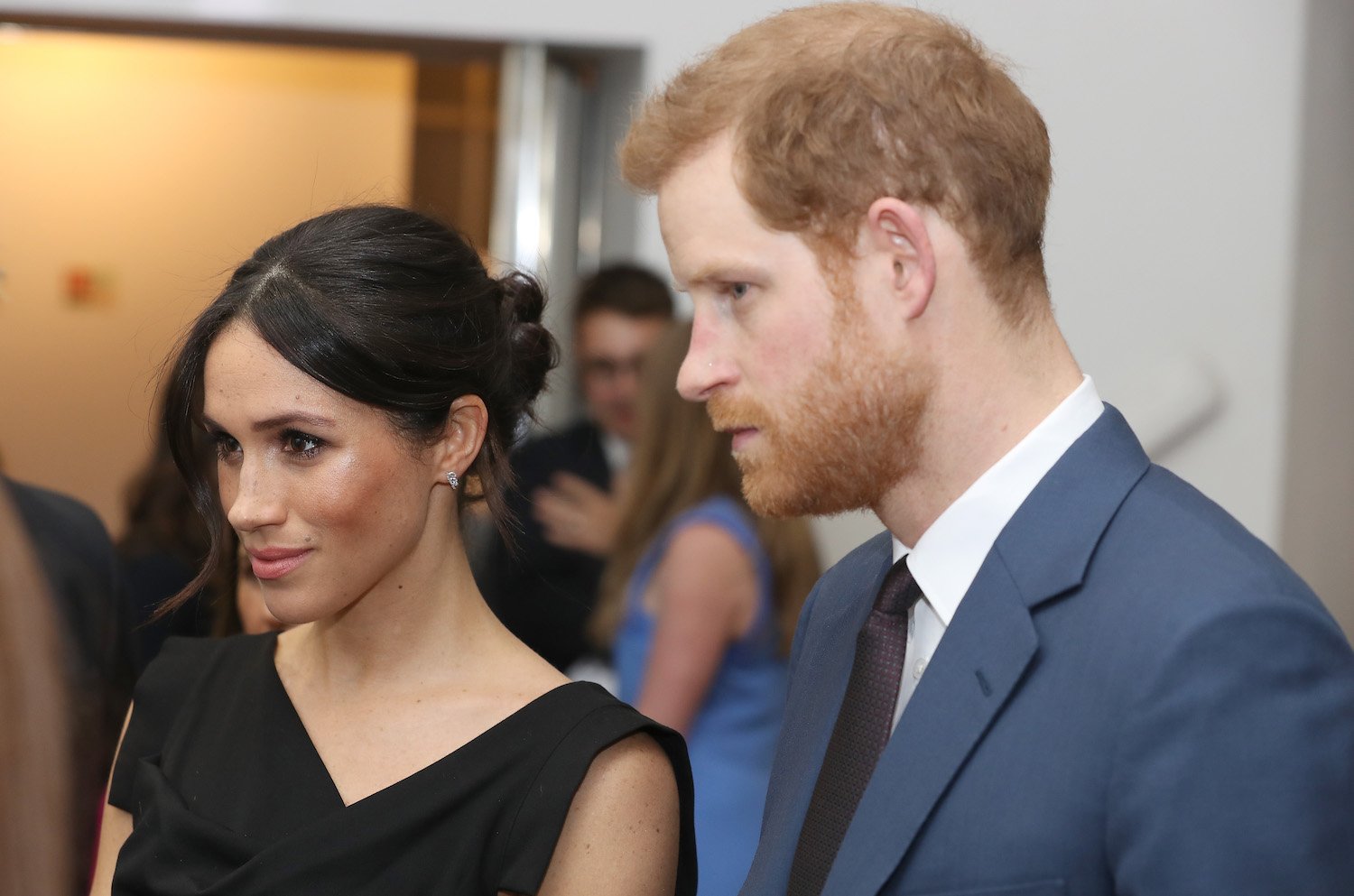 Meghan Markle wears a black dress and Prince Harry wears a suit while attending a Women's Empowerment reception in 2018