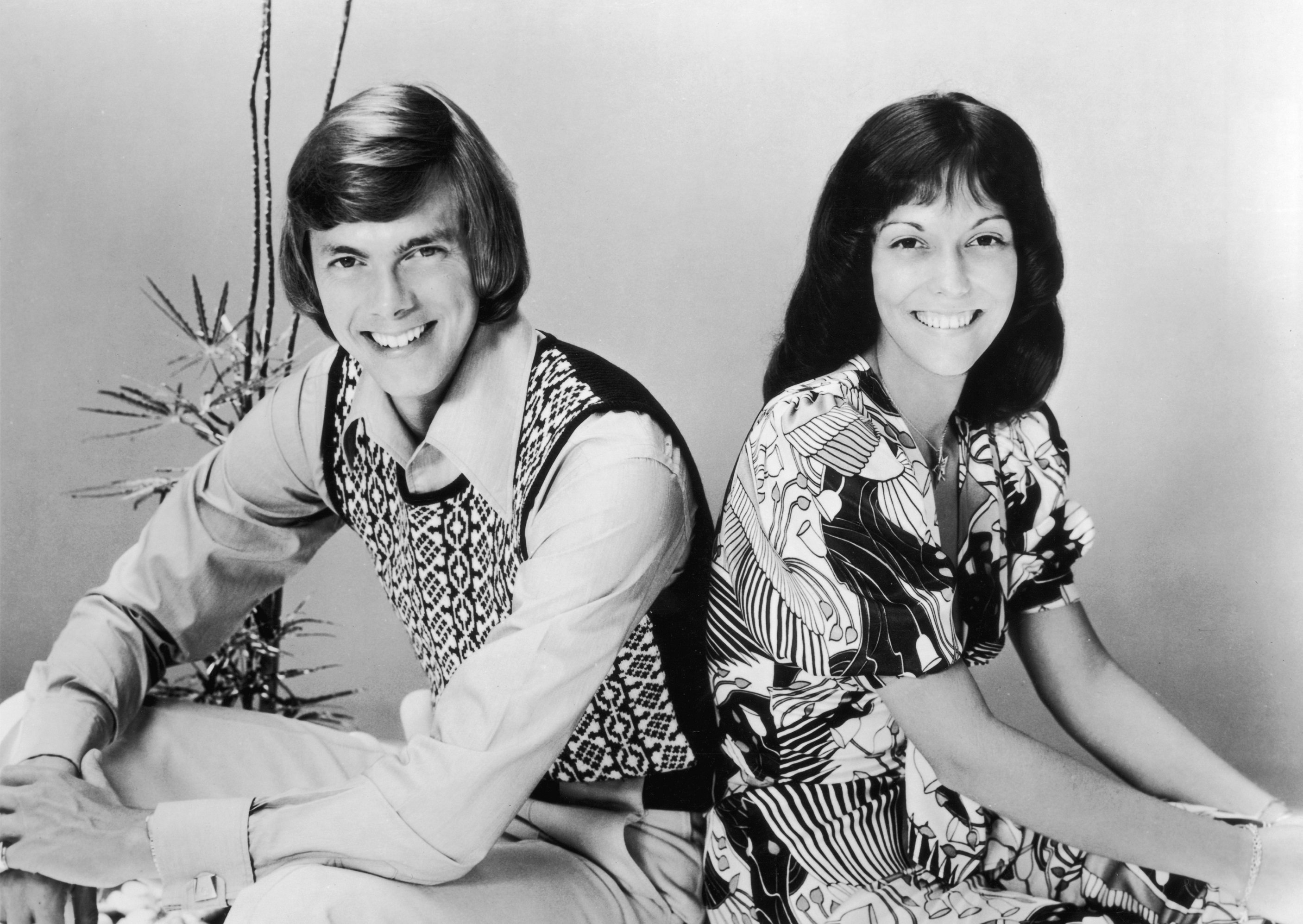 The Carpenters' Richard and Karen Carpenter near a plant