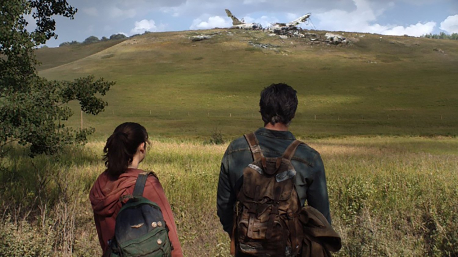 HBOs The Last of Us cast members Bella Ramsey as Ellie and Pedro Pascal as Joel stare at a grass field