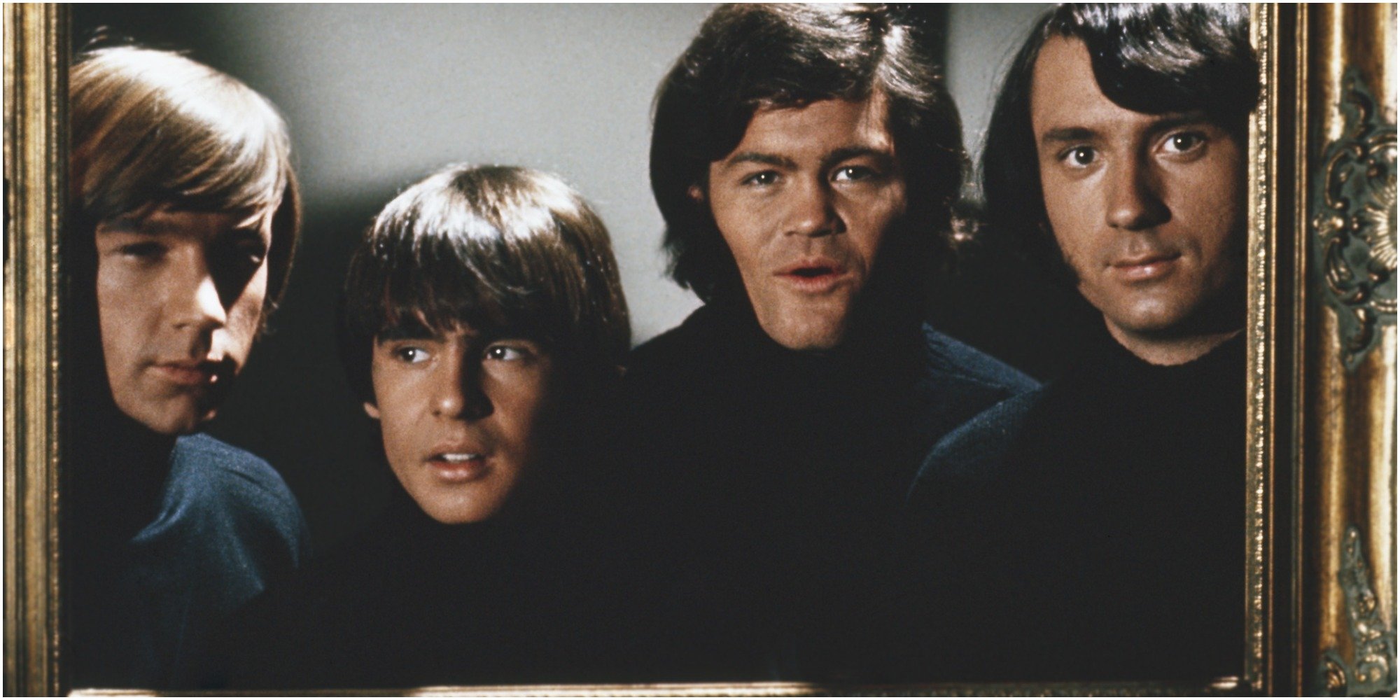 The Monkees pose in a picture frame.