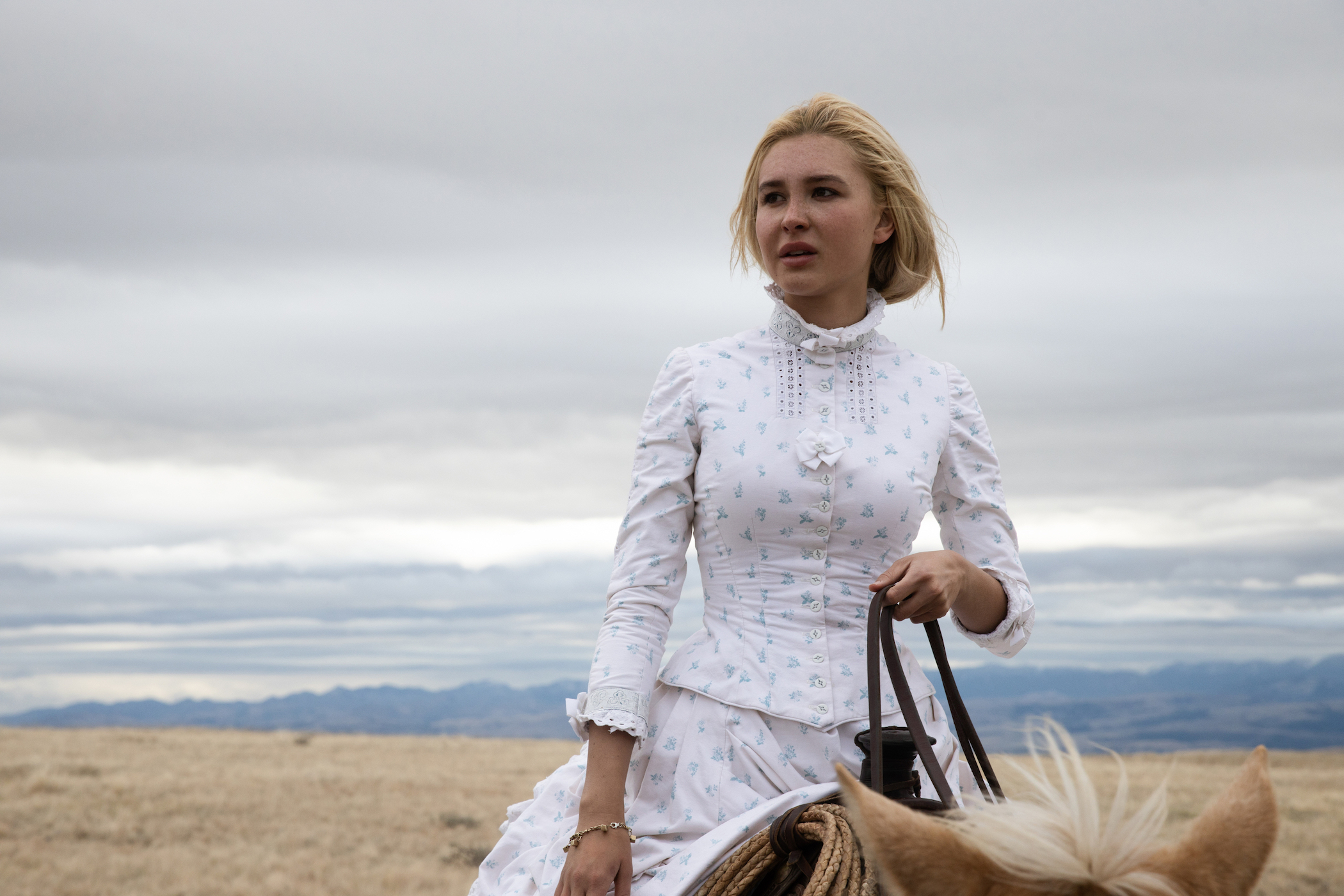 Isabel May as Elsa Dutton riding a horse in a white dress in '1883' episode 9