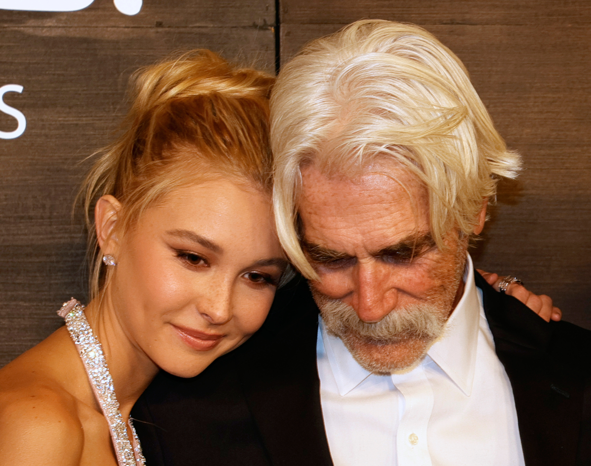 Isabel May leaning on her 1883 co-star Sam Elliott at the world premiere of "1883" at Encore Beach Club at Wynn Las Vegas on December 11, 2021