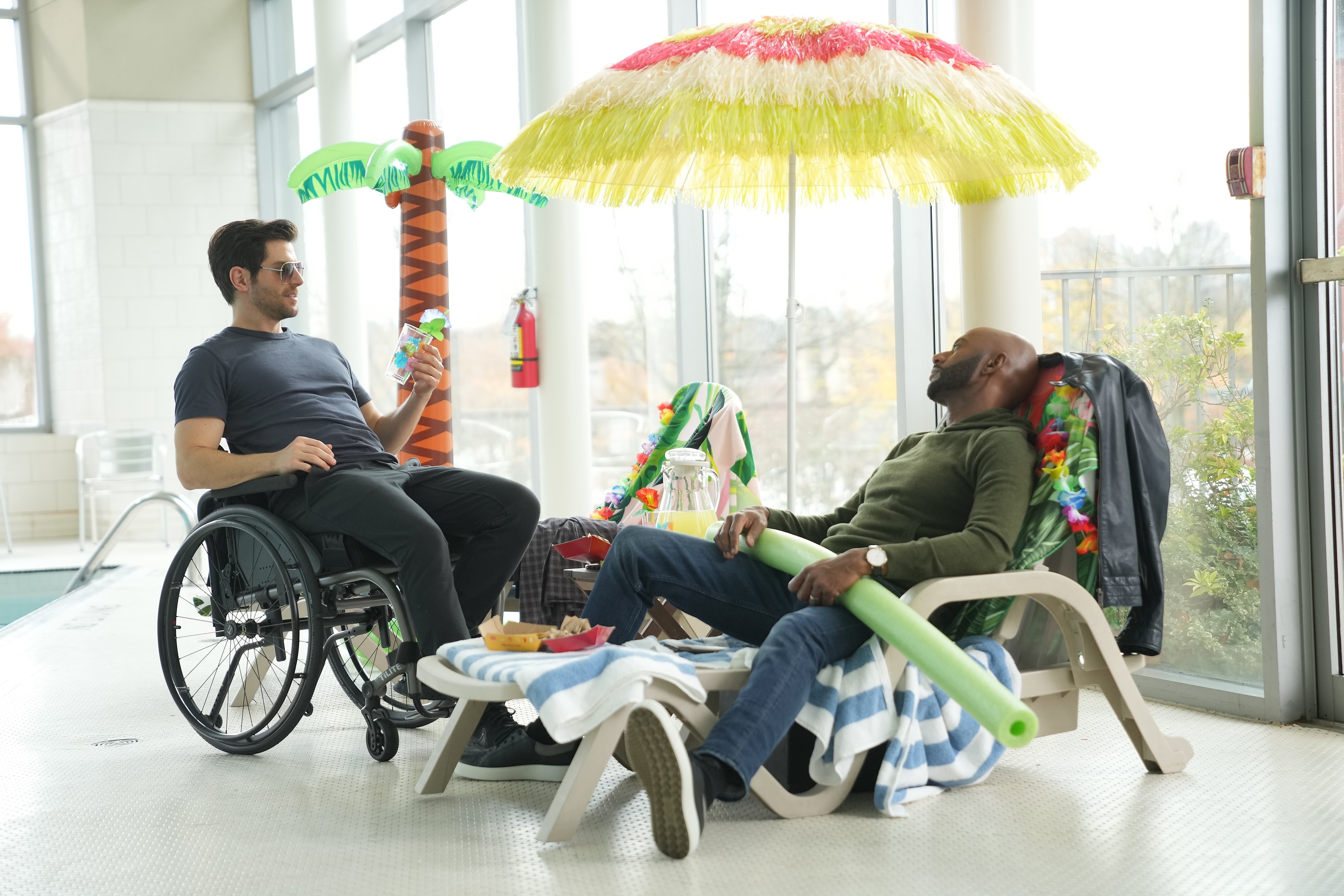 'A Million Little Things' cast members David Giuntoli and Romany Malco lounge in an indoor pool area when the show returns