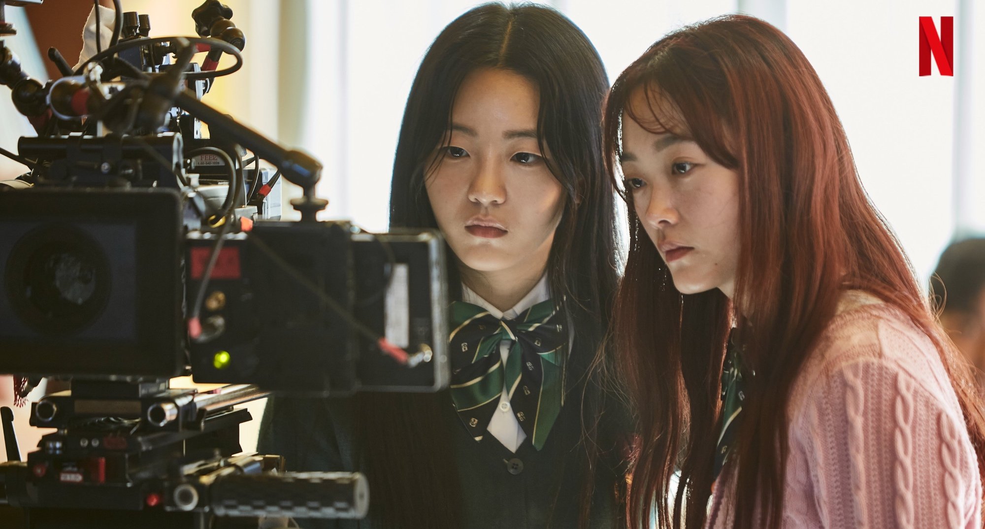 Actors Cho Yi-hyun and Lee Yoo-mi in 'All of Us Are Dead' looking at camera monitor.