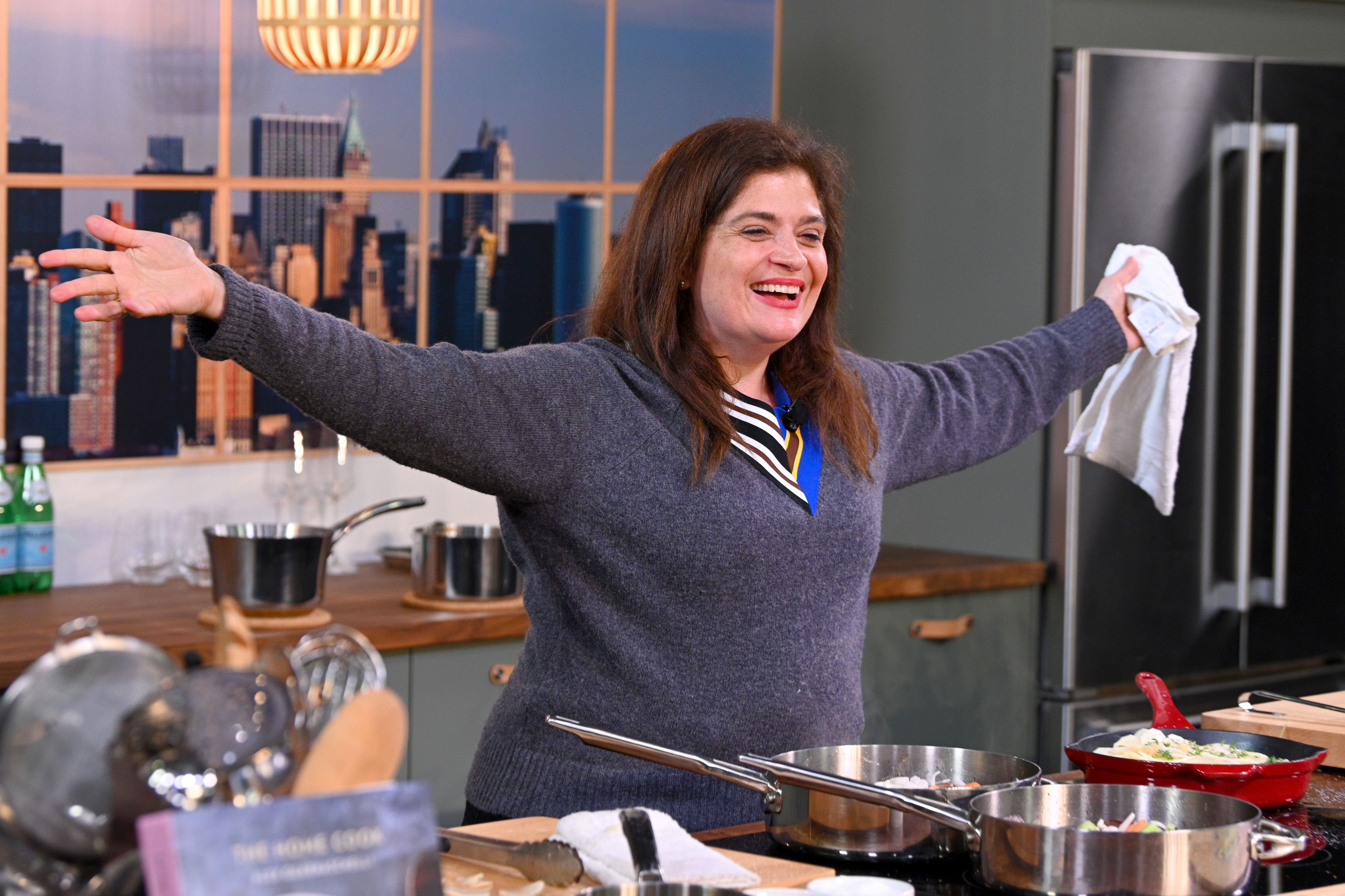 Food Network star Alex Guarnaschelli stretches her arms out during a meal demonstration.