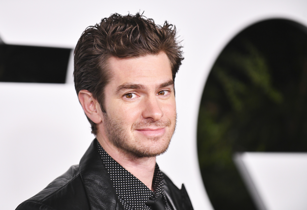 Andrew Garfield looking into the camera in front of a black-and-white background